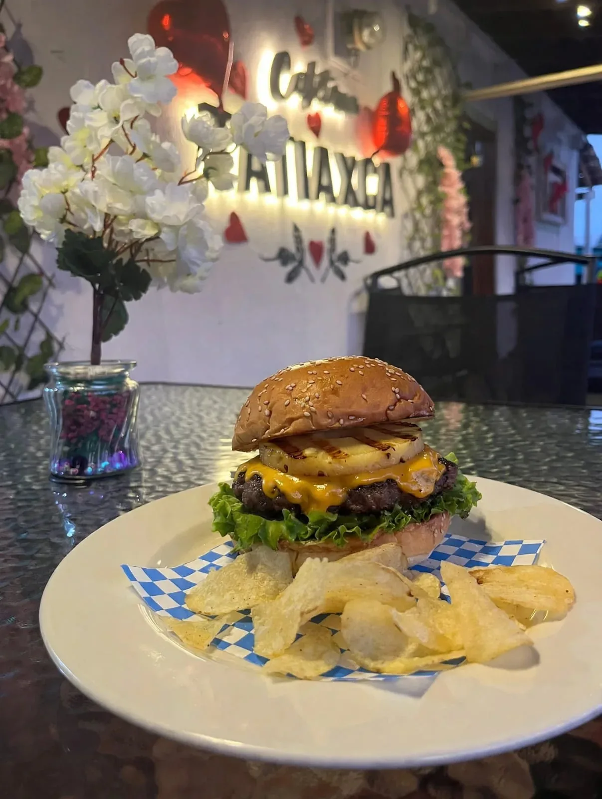 Hamburguesa hawaiana con piña, acompañada de papas onduladas